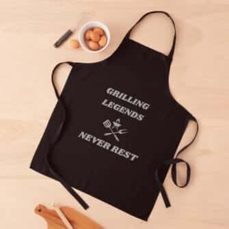 grilling legends never rest on a black apron with white print