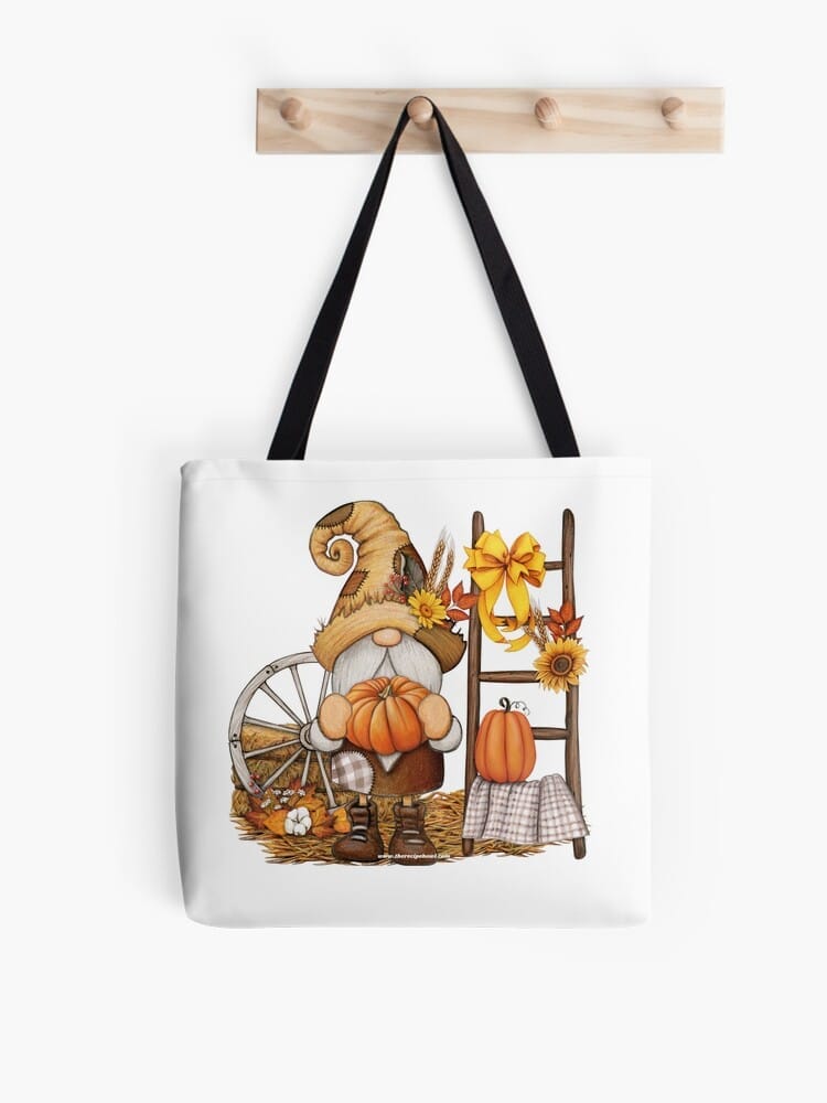 fall greetings tote bag with a knome holding a pumpkin