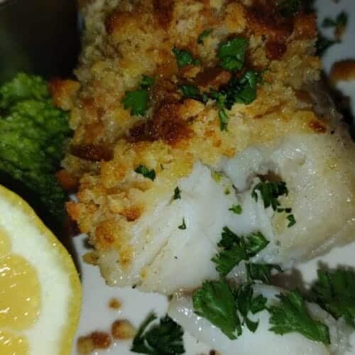 baked haddock on plate with lemon