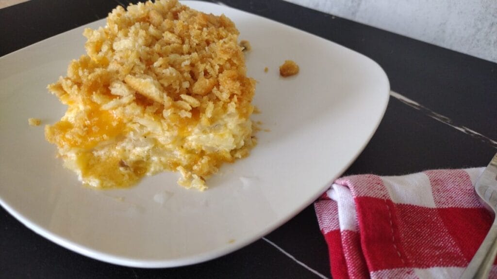 cheesy hashbrown casserole serving on a white plate