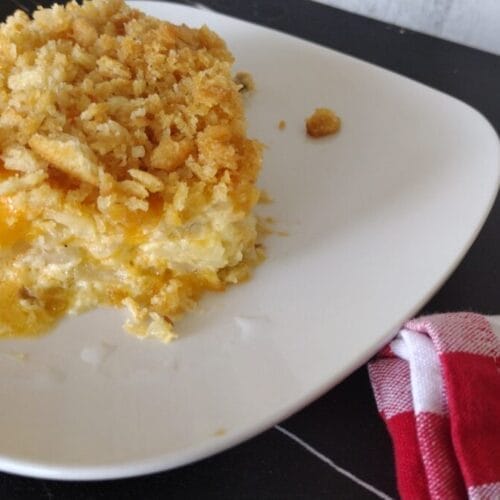 cheesy hashbrown casserole serving on a white plate