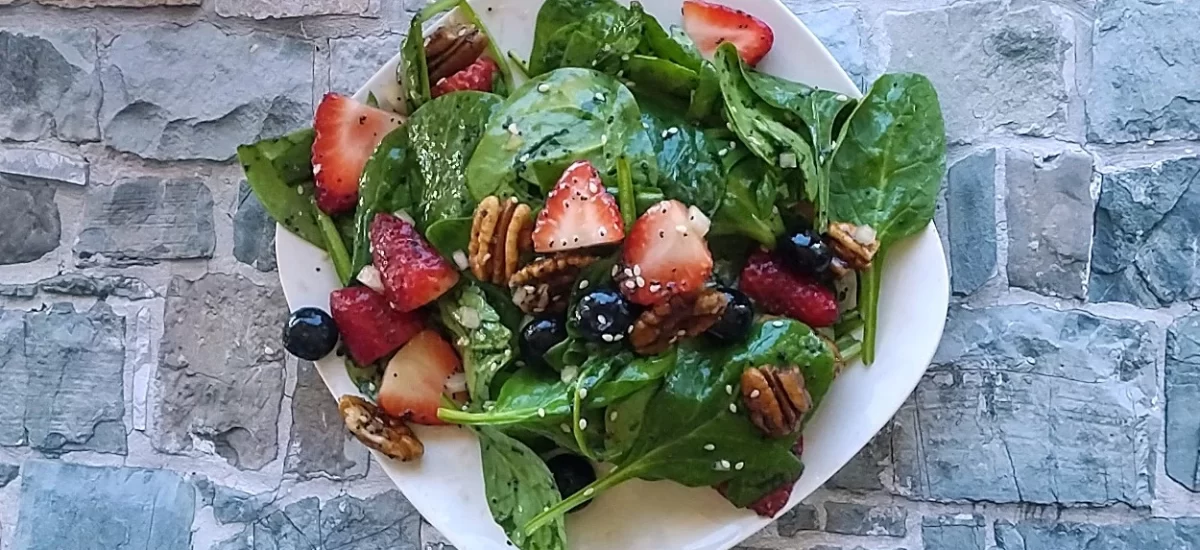 strawberry spinach salad on white plate