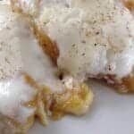 peach cobbler on white plate with a fork