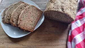 zucchini bread sliced on plate with red white towel on side