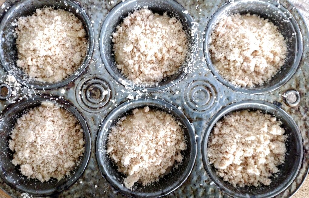 banana muffins with streusel toppings ready to bake in muffin tin