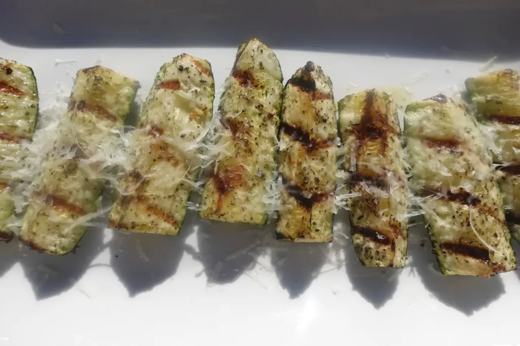 grilled zucchini on white tray with parmesan cheese