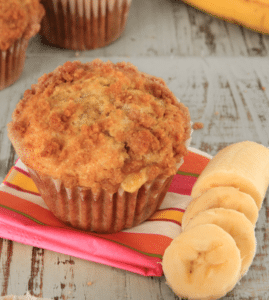 banana muffin on pink striped napkin with sliced bananas