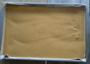 pumpkin roll batter spread in a 10 x 15 jelly roll pan