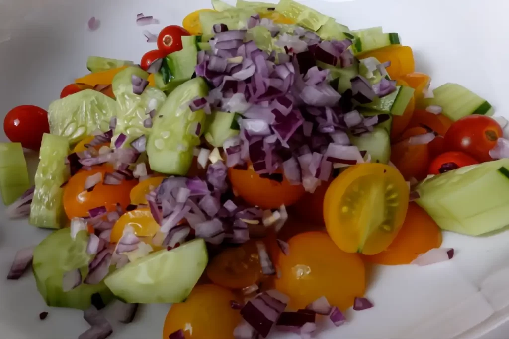 Fresh-cherry-tomatoes-chopped-cucumber-sweet-onionin-a-bowl-ready-to-make-an-easy-grilled-corn-salad-recipe