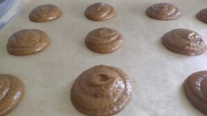 pumpkin whoopie pies piped onto parchment paper