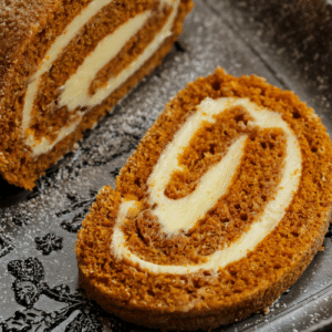 pumpkin roll slice on a black platter