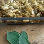 stuffing in 9x13 baking dish with sage leaves