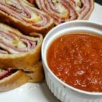 stromboli sliced on white plate with dipping sauce