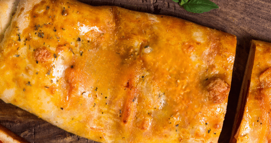 baked stromboli with basil leaves