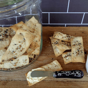 homemade crackers in glass jar and crackers laying beside with spread