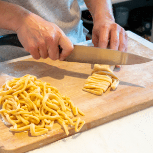 man cutting noodles