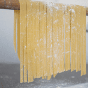 homemade noodles hanging on drying rack