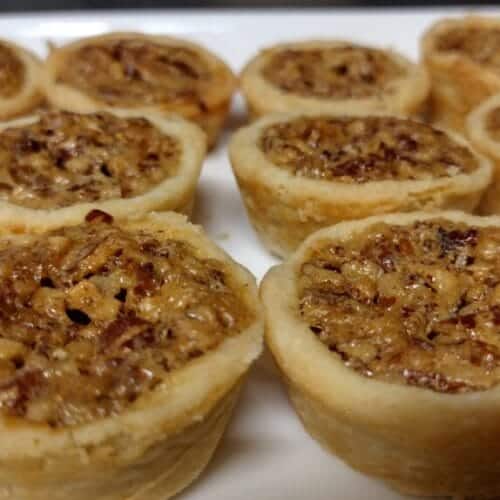 pecan tarts baked on a white serving platter