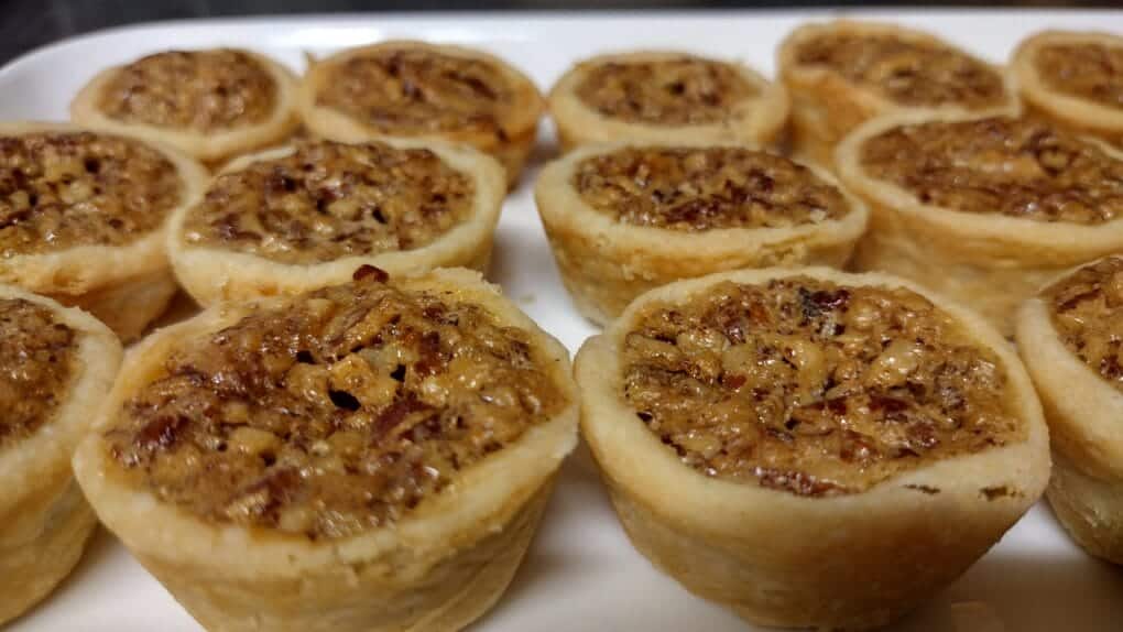 pecan tarts baked on a white serving platter