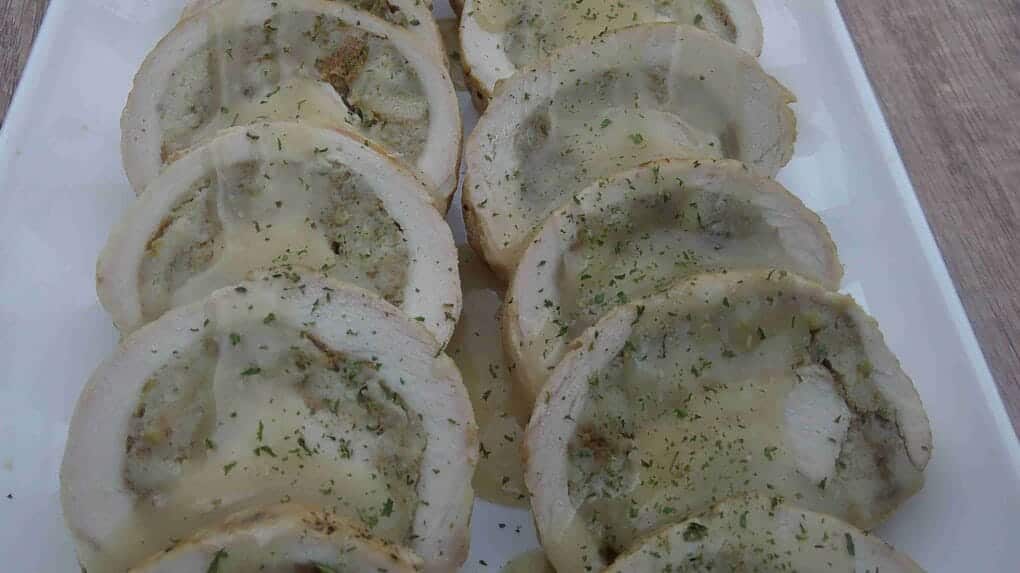 filled pork loin on white tray with gravy