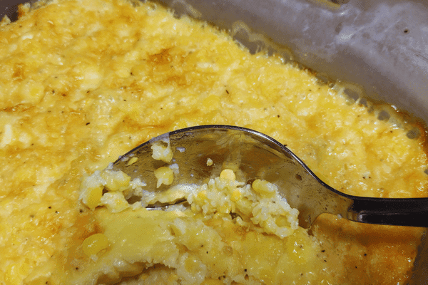 baked corn recipe in a baking dish with a spoon