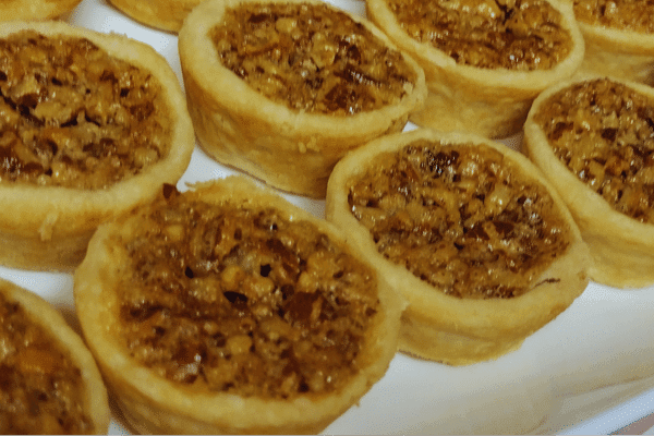 pecan tarts on white platter