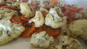 Roasted cauliflower and carrots on white serving tray