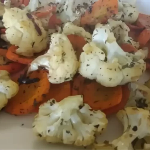 Roasted cauliflower and carrots on white serving tray