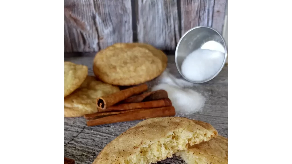 snickerdoodle cookies on tray with sugar and cinnamon sticks