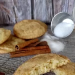 snickerdoodle cookies on tray with sugar and cinnamon sticks