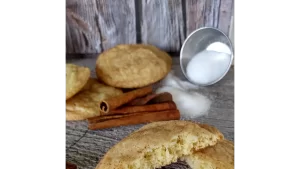 snickerdoodle cookies on tray with sugar and cinnamon sticks