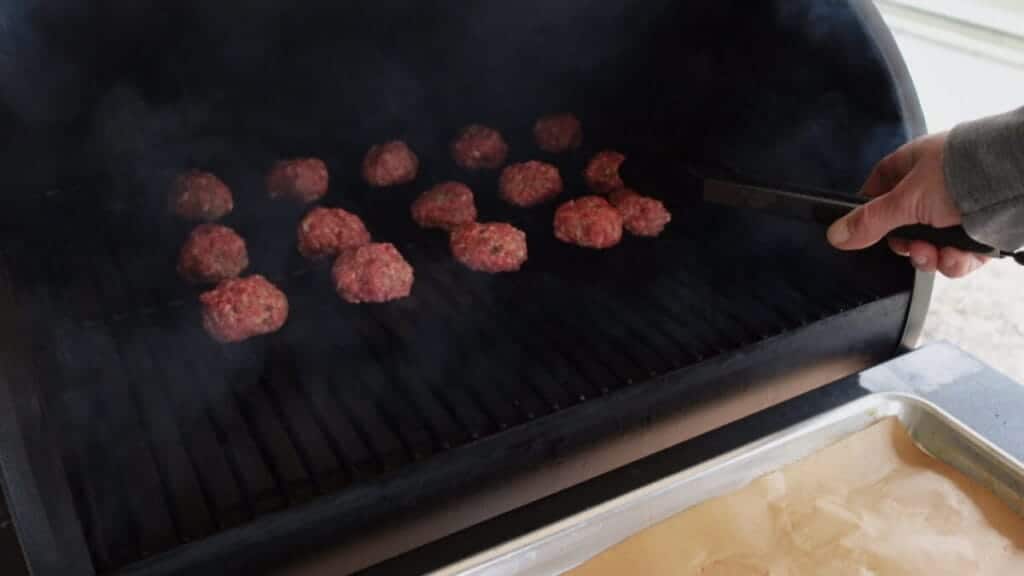 smoked meatballs placed on smoker for smoking