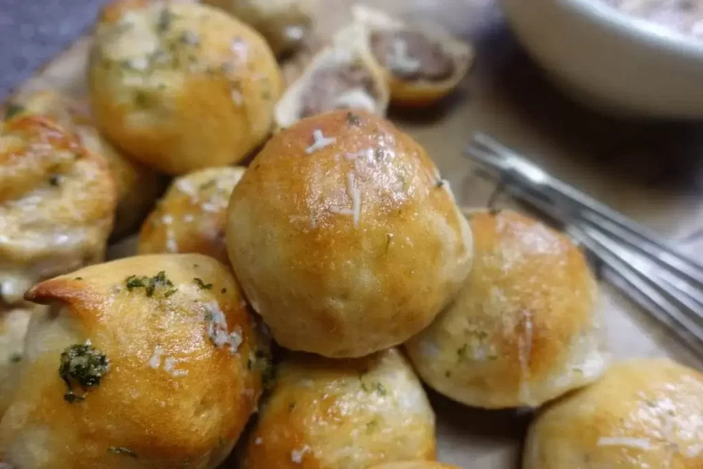 meatball bomb recipe on platter. (meatballs wrapped in dough and baked)