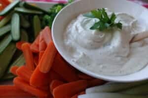 veggie dip on platter with cut up carrots and cucumbers