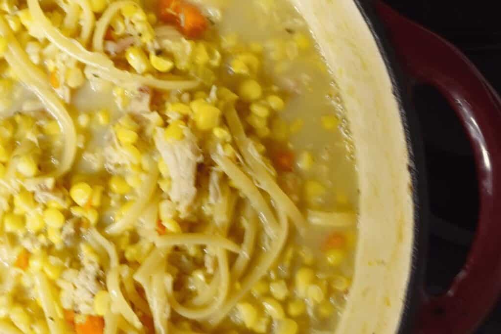 side view of chicken corn soup in a dutch oven