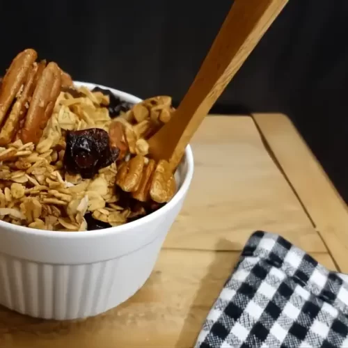 granola-in-small-white-bowl-with-wooden-spoon