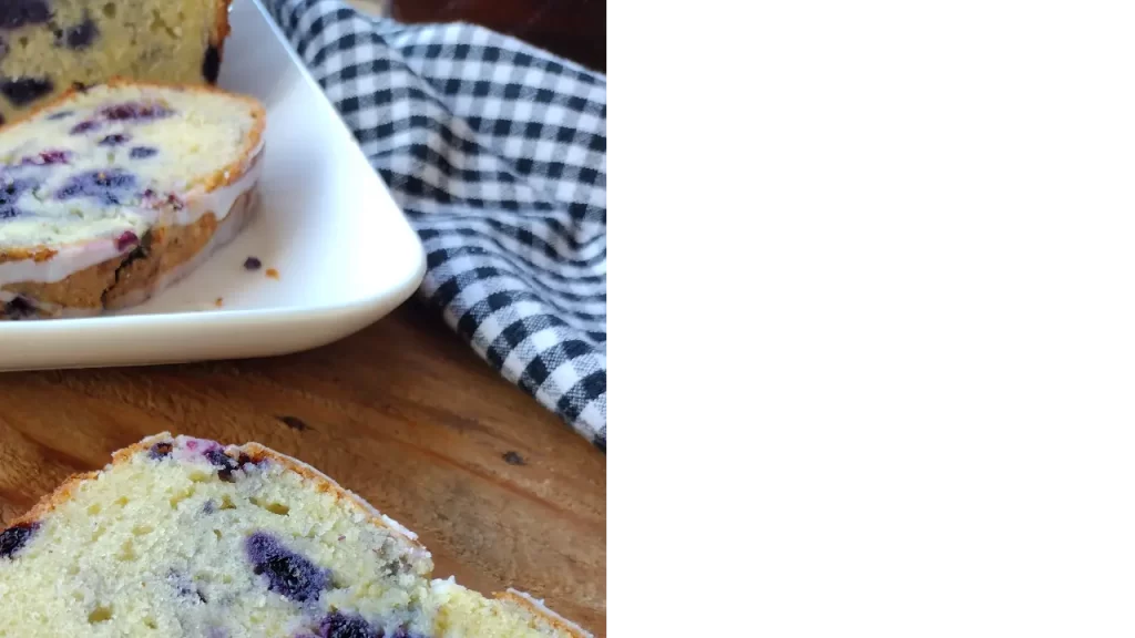 blueberry pound cake on white tray with a black and white checkered towel