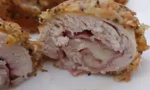 chicken cordon bleu on white plate cut in 1/2