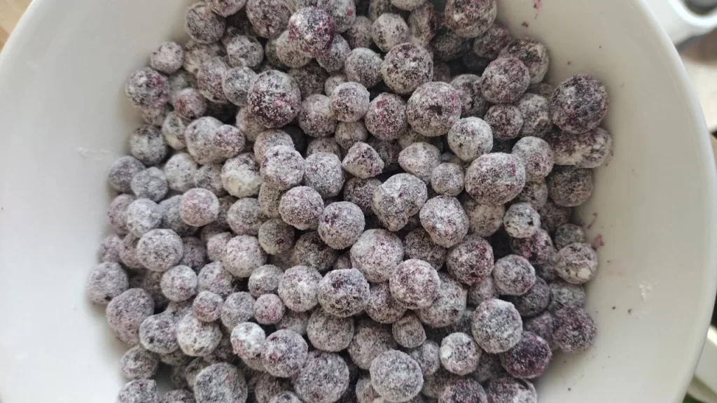 blueberries coated in flour in white bowl