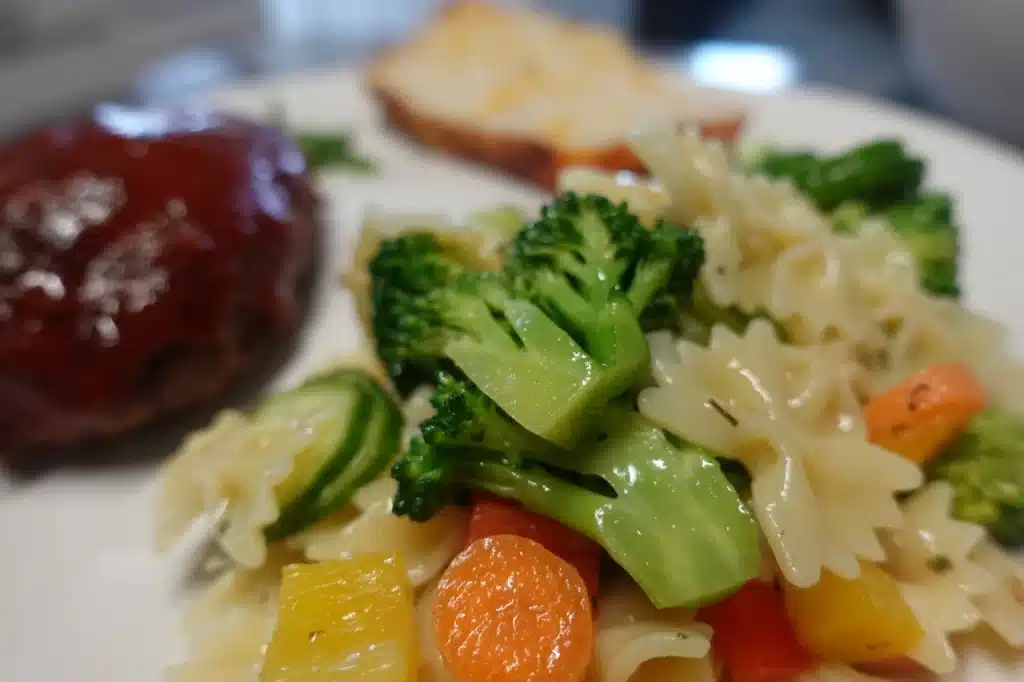 close up of vegetable pasta salad on a white plate