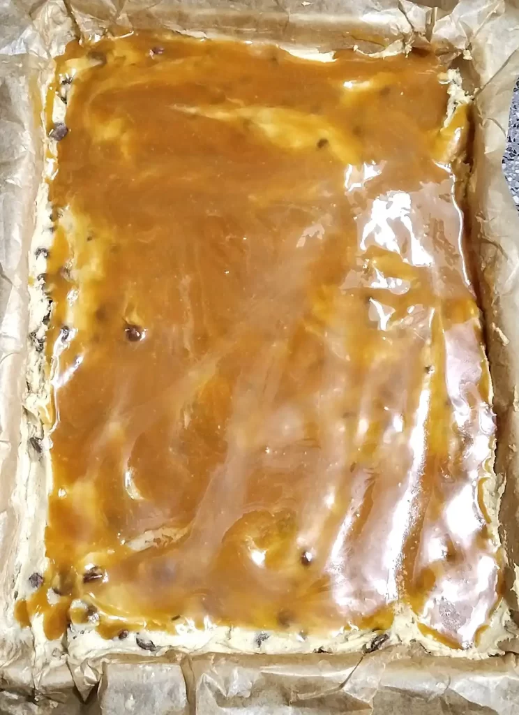 caramel sauce spread chocolate chip cookie dough in 9 x 13