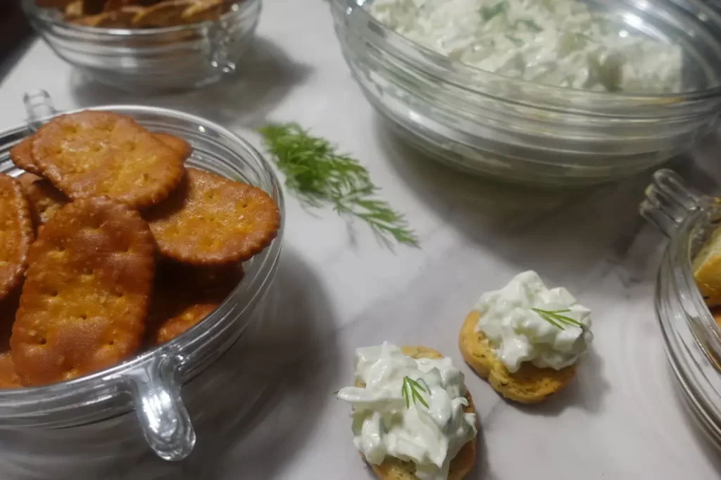 cucumber onion dip with dill and crackers alongside