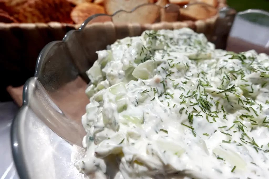 cucumber-onion-dip-in-bowl-with-crackers-in-background.