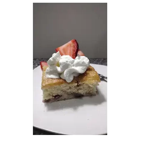 strawberry shortcake recipe on white plate with whipped topping and fresh strawberries