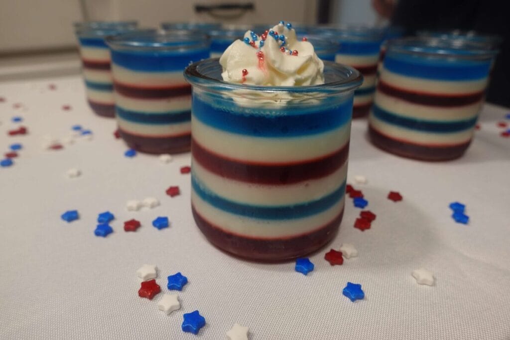 red white and blue jello cups with whipped topping and sprinkles