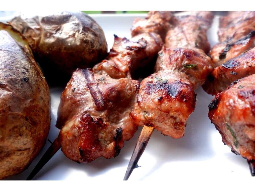 orange pork kabob recipe on white plate