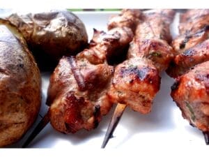 orange pork kabob recipe on white plate