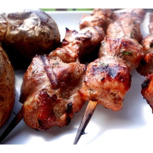 orange pork kabob recipe on white plate