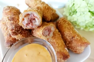 reuben rolls on white plate with dipping sauce