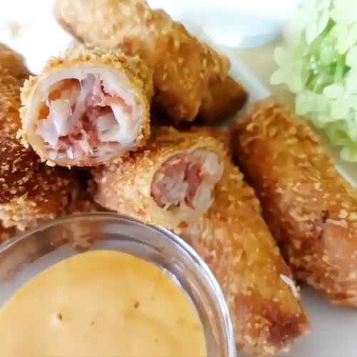 reuben rolls on white plate with dipping sauce